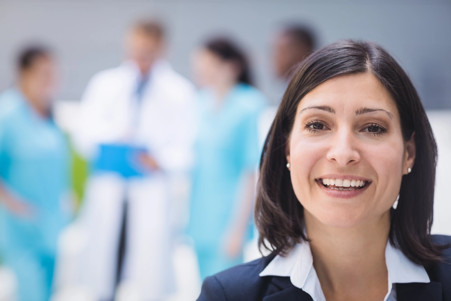 Image of woman smiling in dental clinic with blurry background | Plano Smile Studio